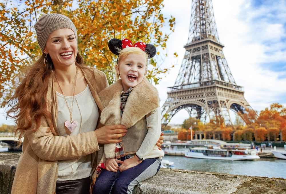 Mamma e bambina con le orecchie di Minnie davanti alla Torre Eiffel a Parigi in autunno