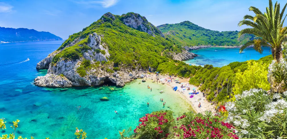 Spiaggia di Corfù vista dall'alto, con il promontorio verde e il mare