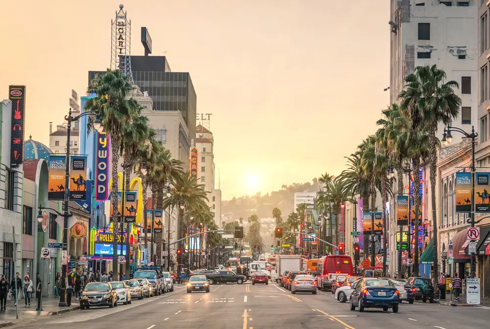 Hollywood Boulevard a Los Angeles al tramonto, con le palme e le insegne