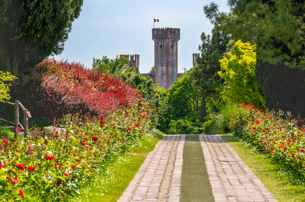 The parco giardino Sigurta gardens with the Castle of Valeggio sul Mincio on the background near Verona - Veneto region - Italy landmarks .